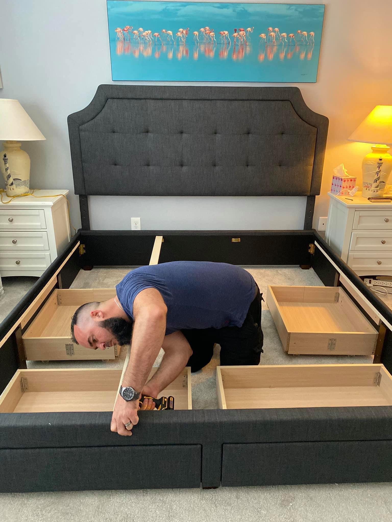 Mattress Direct team member assembling a bed frame in a customer bedroom